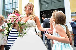 Barn blåser såpbubblor på bruden